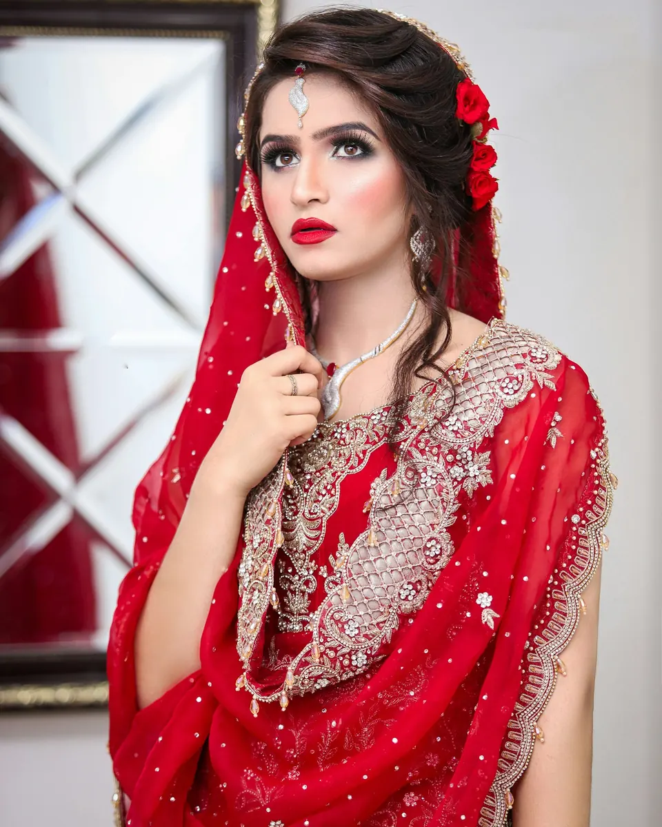 A bride in a red embroidered dupatta with soft glam makeup